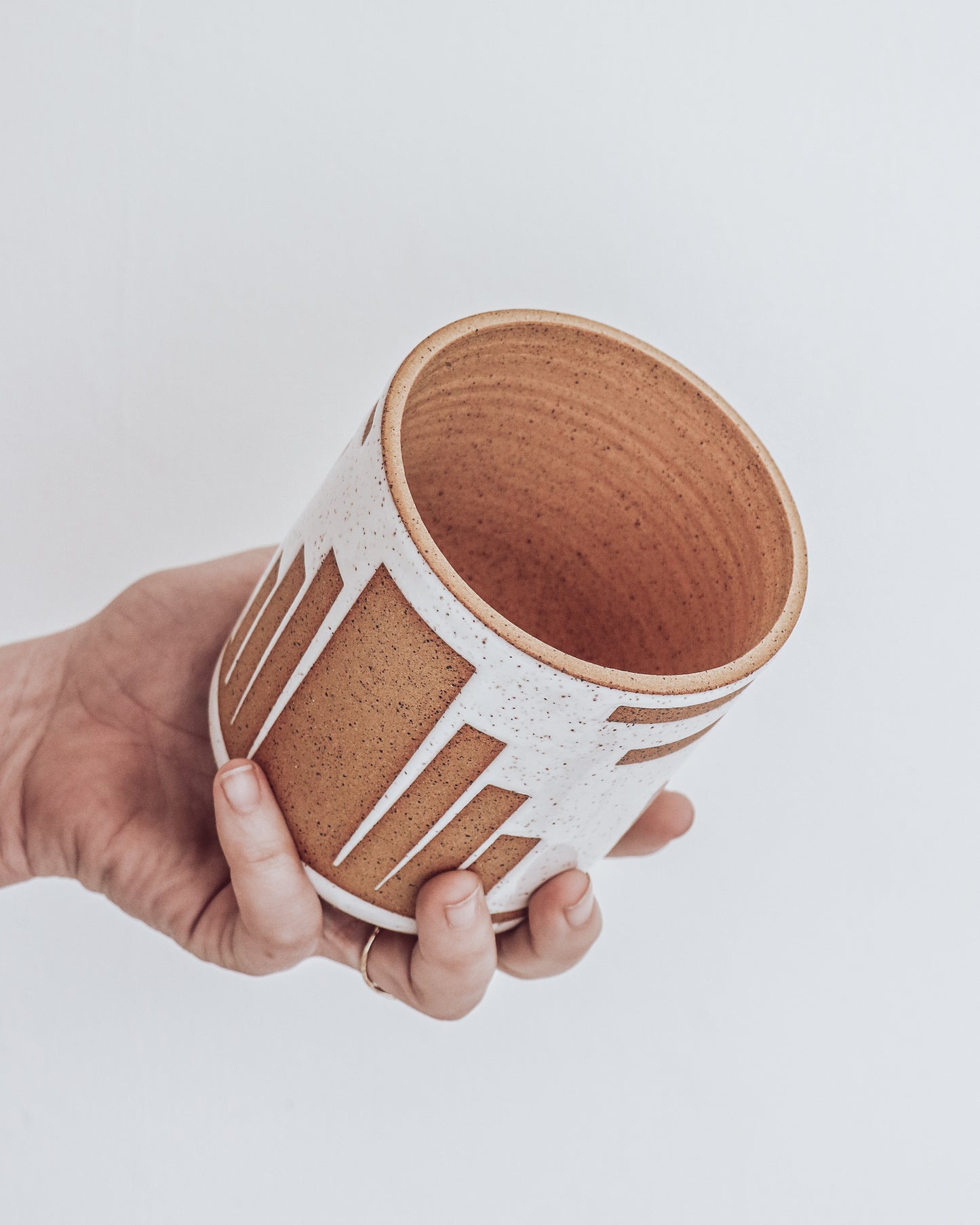 Art Deco Planter in white speckled glaze with geometric detailing, shown held in hand for scale.