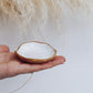 Stone Ring Dish in glossy white glaze with raw clay edge, shown held in hand for scale.